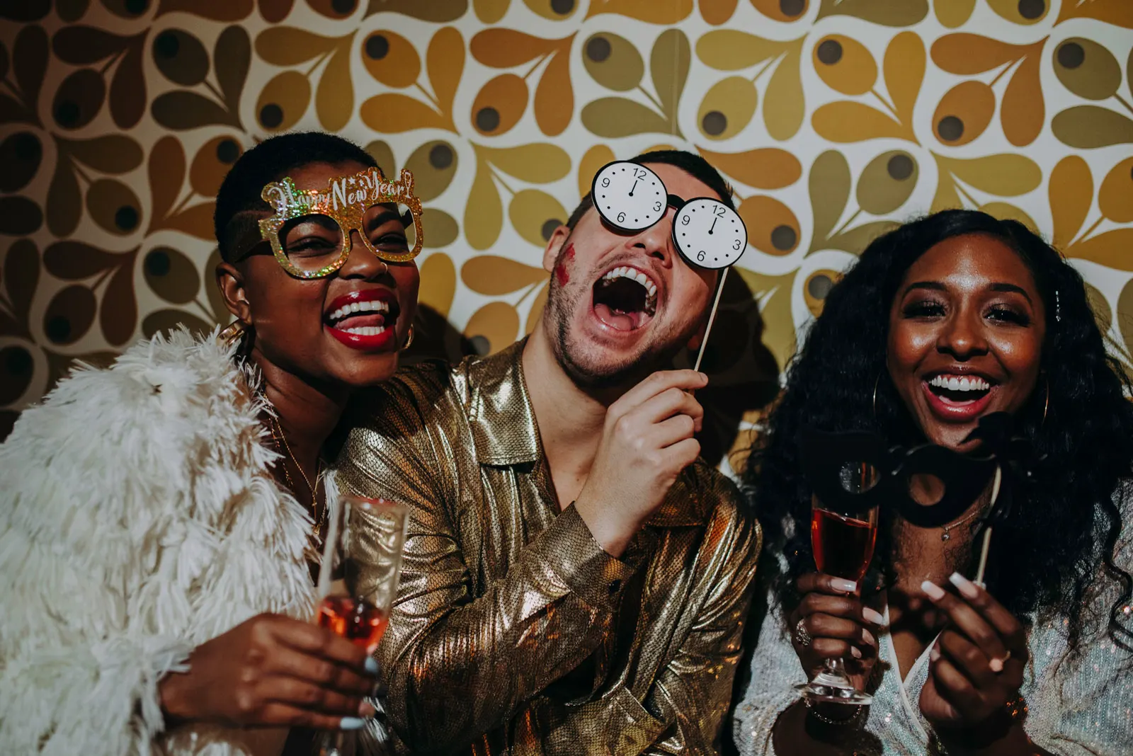 Friends celebrating together with props in front of a GLOWSHOT photo booth