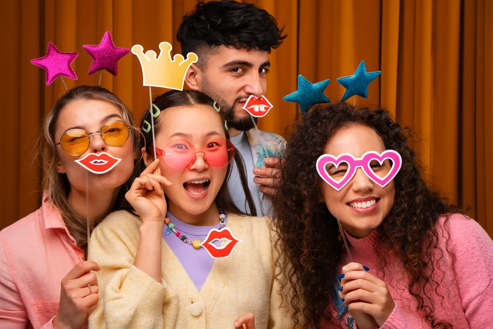 Guests posing with colorful props at a GLOWSHOT photo experience